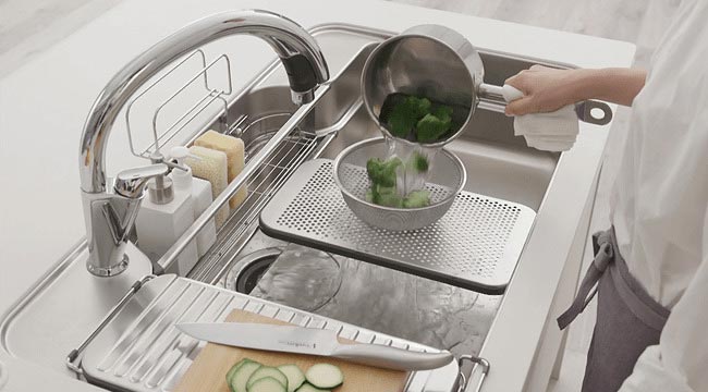 食材をカットする手を止めて、茹で上がった野菜の水切り。Wサポートシンクなら調理スペース広々。