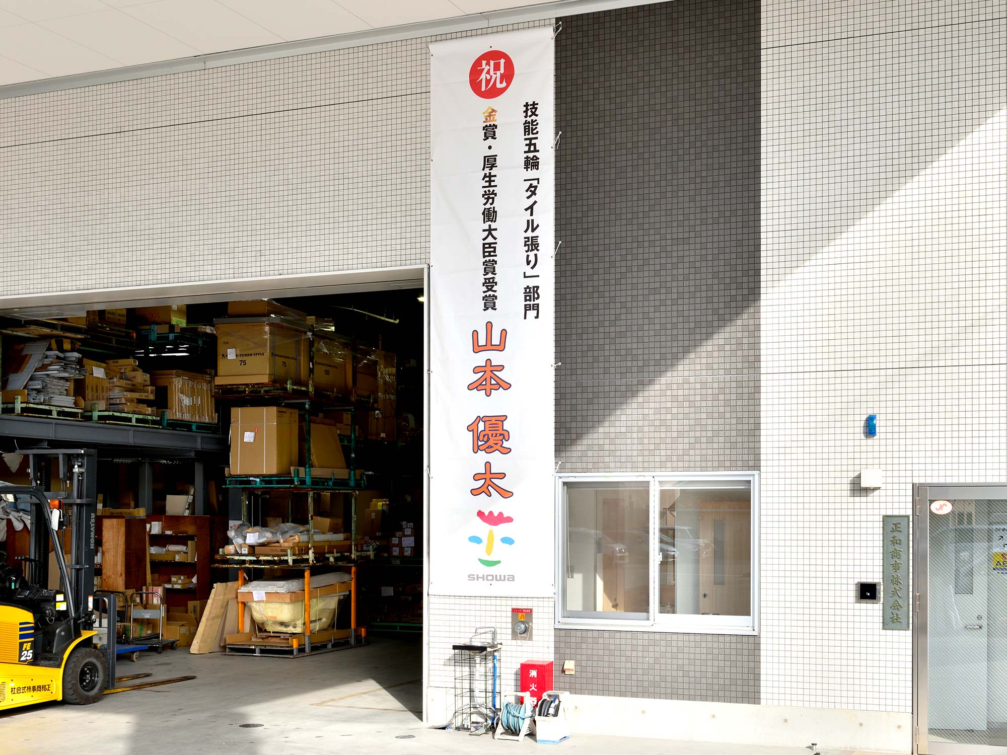 松山営業所に掲げられた垂れ幕は、お得意様から金賞受賞のお祝いにいただいたもの。
