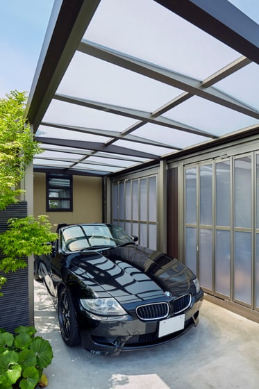 半透明のパネルの屋根から射す光が、車をより美しく見せてくれるカーポート。の写真