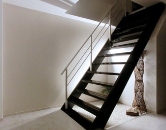 玄関ホールから居住スペースに行く階段。の写真
